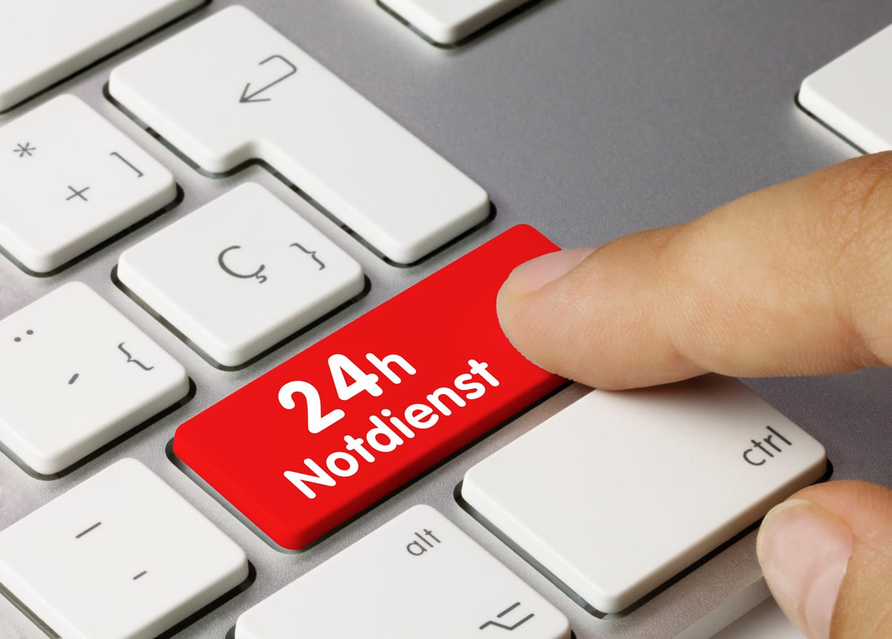 Zu sehen ist eine Tastatur mit einen 24h Notdienst in rot. Ein Finger zeigt auf die Taste.